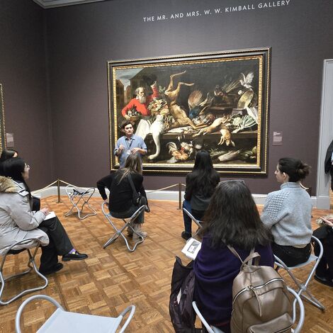 WIR event. Women sit in front of painting with a speaker